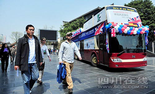 在寬窄巷子，幾位外國游客從世博大巴旁經過
